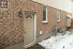 Guelph (Kortright East) apartment for rent - A house with a brown brick wall and a white door.