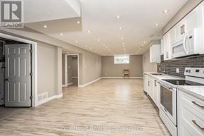 Guelph (Kortright East) apartment for rent - A spacious kitchen with white appliances and wooden flooring.