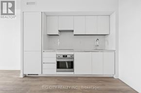Toronto (Thorncliffe Park) condo for rent - A white kitchen with a stove top oven and a refrigerator.