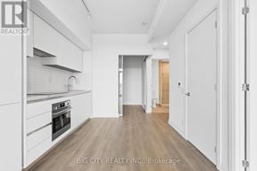 Toronto (Thorncliffe Park) condo for rent - A white kitchen with a wood floor and a white wall.