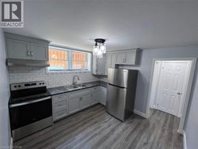 Kitchener apartment for rent - A kitchen with a stove, sink, and refrigerator.