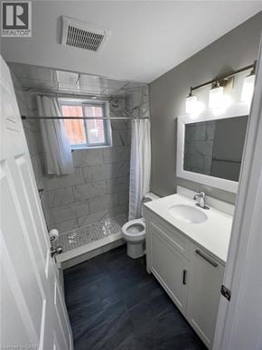 Kitchener apartment for rent - A bathroom with a toilet, sink, and shower.