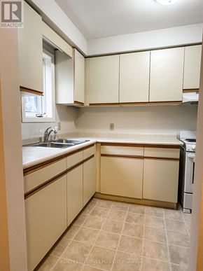 Orangeville multi-family for rent - A kitchen with beige cabinets and a tiled floor.
