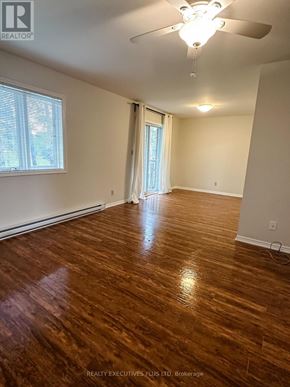 Orangeville multi-family for rent - A room with wooden flooring and a ceiling fan.