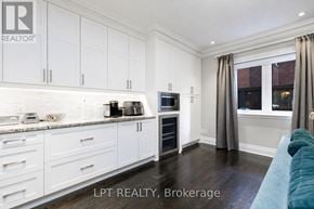 Toronto (Leaside) townhouse for rent - A kitchen with white cabinets and a blue couch.