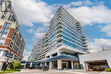 Mississauga (Central Erin Mills) condo for rent - A modern multi-story building with a glass facade and a parking area in front.