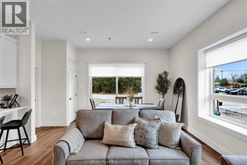 Tilbury apartment for rent - A living room with a grey couch and a window overlooking a street.