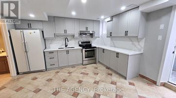 Vaughan (Patterson) apartment for rent - A kitchen with white cabinets and a tiled floor.