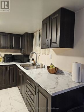 Toronto (Woburn) apartment for rent - A kitchen with dark wood cabinets and marble countertops.