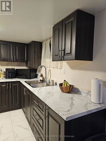 Toronto (Woburn) apartment for rent - A kitchen with dark wood cabinets and marble countertops.
