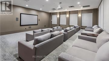 Toronto (Mimico) condo for rent - A living room with a row of couches and a large screen on the wall.