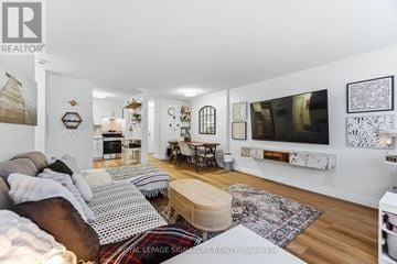 Oakville (Br Bronte) condo for rent - A living room with a couch, a coffee table, and pictures on the wall.