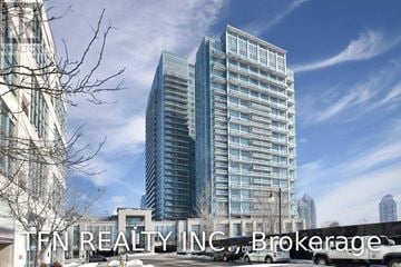 Toronto (Mimico) condo for rent - Two tall buildings with a tree in the foreground and a cloudy sky in the background.