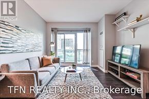 Toronto (Mimico) condo for rent - A living room with a grey sofa, a coffee table, and a television on a wooden stand.