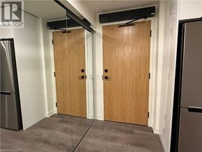 Brantford condo for rent - A room with two wooden doors and a refrigerator on the left side.