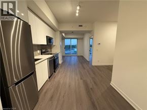 Brantford condo for rent - A kitchen with a refrigerator, microwave, and oven.