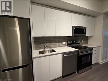 Brantford condo for rent - A modern kitchen with white cabinets and stainless steel appliances.
