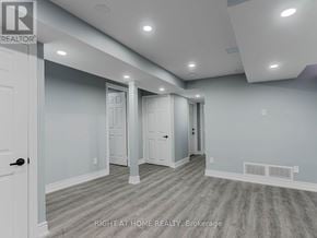 Vaughan (Maple) apartment for rent - A spacious room with a door on the left and a hallway leading to another room.