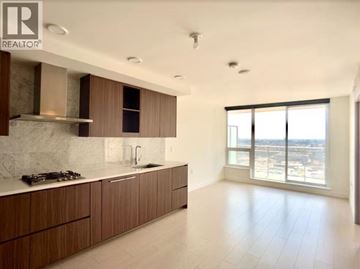 Vancouver apartment for rent - A modern kitchen with wooden cabinets and a marble backsplash.