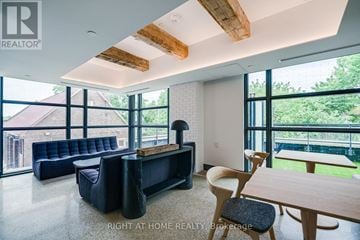 Toronto (Junction Area) condo for rent - A living room with a black couch and a wooden table.