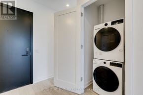Toronto (Junction Area) condo for rent - A washing machine is in a small room with a door.