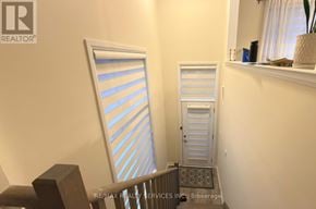 Hamilton (Stoney Creek Mountain) townhouse for rent - A white door with a window on the side is in a hallway.