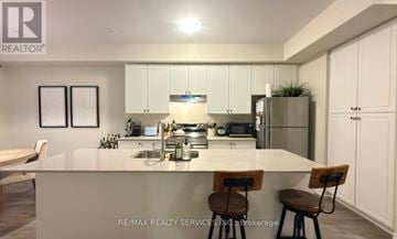 Hamilton (Stoney Creek Mountain) townhouse for rent - A modern kitchen with white cabinets and a central island.