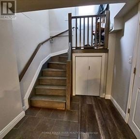 Oshawa (Mclaughlin) multi-family for rent - A staircase with a wooden handrail and a white wall.