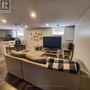 Oshawa (Mclaughlin) multi-family for rent - A living room with a couch, a television, and a coffee table.