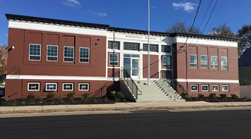 Sanford apartment for rent - A red brick building with a white sign on the front.