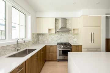 Victoria apartment for rent - A modern kitchen with wooden cabinets and stainless steel appliances.