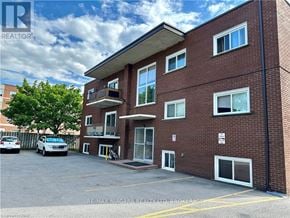 St. Catharines (Carlton/Bunting) condo for rent - A building with a parking lot in front of it.