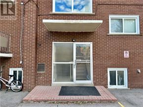 St. Catharines (Carlton/Bunting) condo for rent - A red brick building with a glass door and a no parking sign on the wall.