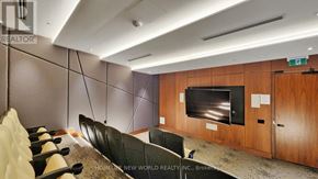 Toronto (Mount Pleasant West) condo for rent - A modern home theater room with a row of black chairs facing a large screen.