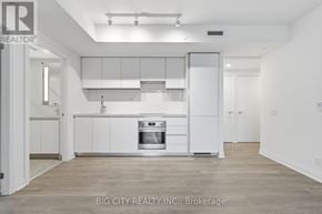 Toronto (Thorncliffe Park) condo for rent - A white kitchen with a stove top oven and a refrigerator.