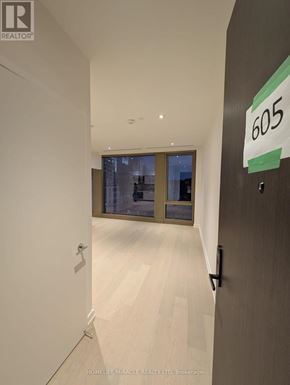 Toronto (Annex) condo for rent - A hallway with a door on the right and a sign that says 605.