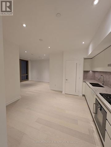 Toronto (Annex) condo for rent - A spacious kitchen with white cabinets and a tiled backsplash.