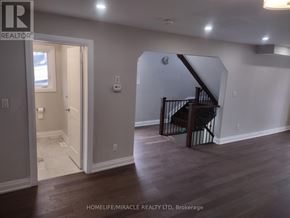 Toronto (Kennedy Park) apartment for rent - A room with a staircase and a door leading to another room.