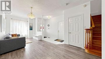Richmond Hill (Rouge Woods) townhouse for rent - A well-lit, spacious living room with a grey sofa and a chandelier.