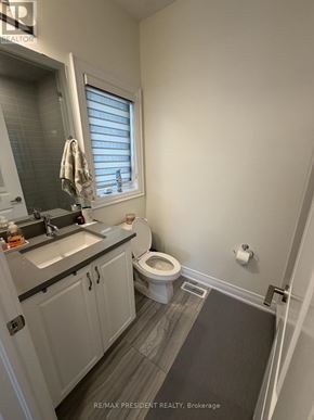 Vaughan (Vellore Village) apartment for rent - A bathroom with a toilet, sink, and a window.