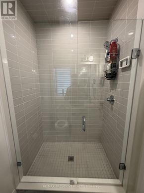 Vaughan (Vellore Village) apartment for rent - A shower stall with a glass door and a white tile floor.