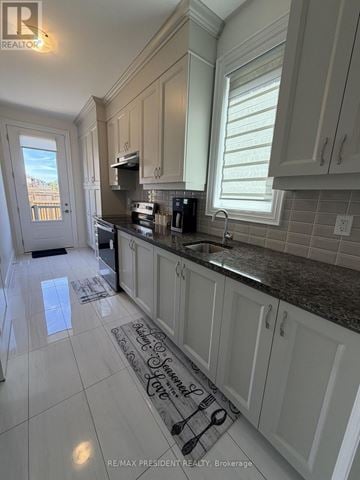 Vaughan (Vellore Village) apartment for rent - A kitchen with white cabinets and a black stove top oven.