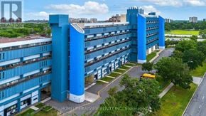 Toronto (Black Creek) condo for rent - A large blue building with a parking lot in front of it.