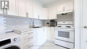 Toronto (Black Creek) condo for rent - A white kitchen with a washer and dryer built in.