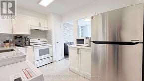 Toronto (Black Creek) condo for rent - A kitchen with white cabinets and appliances.