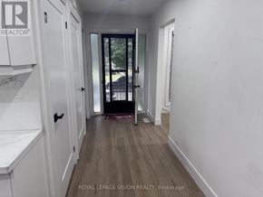 Niagara Falls (Church's Lane) apartment for rent - A hallway with white walls and wood flooring, leading to a black door.