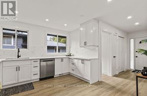 Niagara Falls (Church's Lane) apartment for rent - A kitchen with white cabinets and a marble countertop.