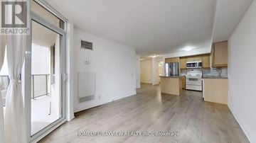 Toronto (Willowdale East) condo for rent - A spacious kitchen with wooden cabinets and a white fridge is shown in the image.