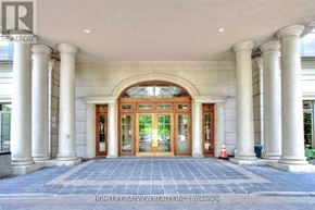 Toronto (Willowdale East) condo for rent - A building entrance with a large arched doorway and columns on either side.