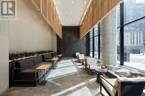 Toronto (Church-Yonge Corridor) condo for rent - A modern waiting area with black and white furniture and a view of the city outside the windows.